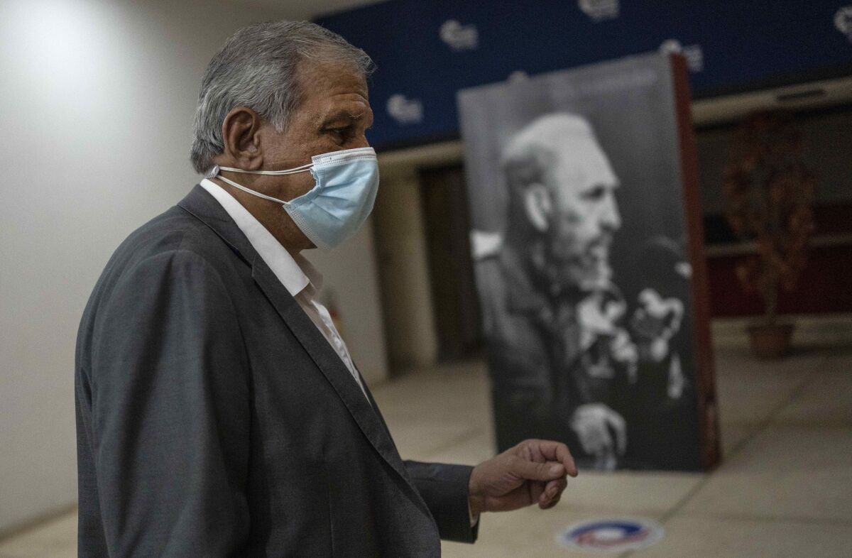 Mitchell Joseph Valdes Sosa, the director of the Cuban Neurosciences Center, walks past a photo of Fidel Castro before a press conference about symptoms reported by U.S. and Canadian diplomats in 2016 and 2017, commonly referred to as the “Havana Syndrome," in Havana, Cuba, Monday, Sept. 13, 2021. (AP Photo/Ramon Espinosa)