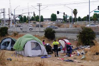 Chula Vista, CA - August 11: On Friday, Aug. 11, 2023, in Chula Vista, CA, transit security and public officers with the San Diego Metropolitan Transit System inform those in the encampment that they have four hours to vacate the private property between Oxford and Palomar Street, or they will be prosecuted. The two security men were also posting notice signs saying "No trespassing" and explaining they had 4 hours to vacate or face prosecution. (Nelvin C. Cepeda / The San Diego Union-Tribune)