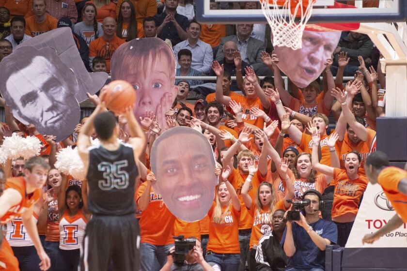 FILE - The Illinois Orange Krush student section uses large heads to heckle Chicago State's Clarke Rosenberg (35) as he tries for a foul shot during the second half of an NCAA college basketball game on Nov. 22, 2013, in Champaign, Ill. The Illinois student spirit group “Orange Krush” had its order for 200 tickets to the men's basketball game at Carver-Hawkeye Arena on Saturday, Feb. 4, 2023, canceled, after Iowa discovered the person who made the purchase falsely claimed the tickets were for a Boys and Girls Club. (AP Photo/Darrell Hoemann, File)