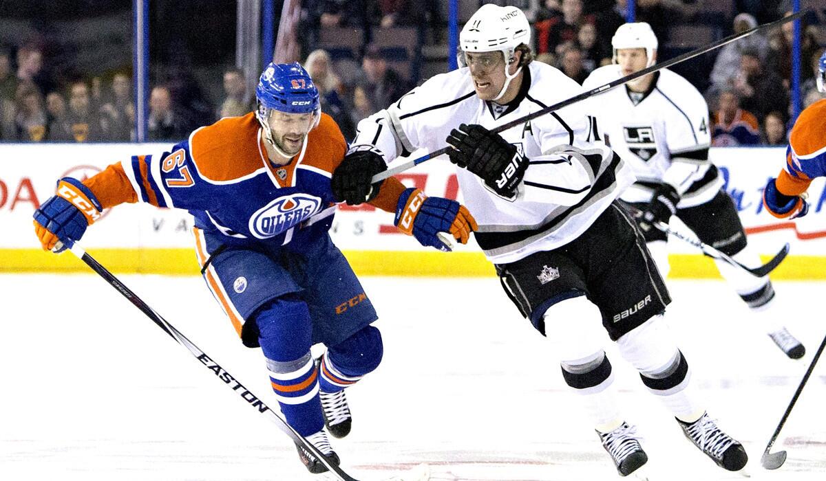 Los Angeles' Anze Kopitar and Edmonton's Benoit Pouliot chase the loose puck during the Kings' 5-2 victory over the Oilers on Tuesday.