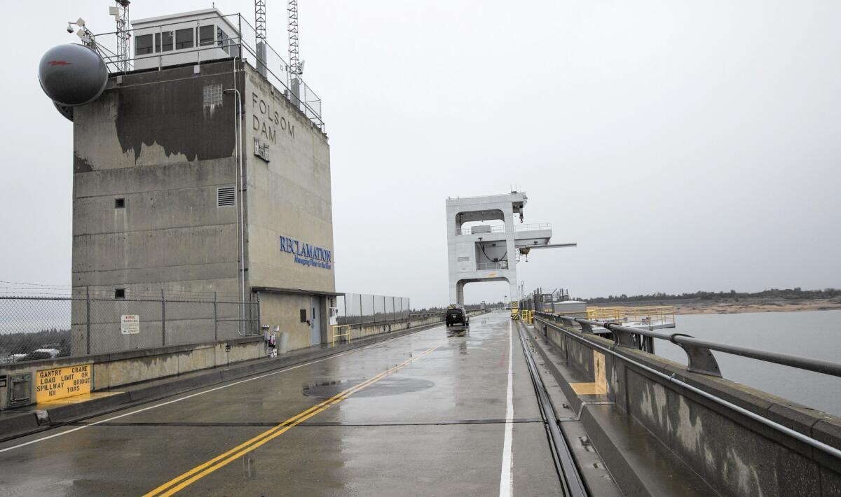 After months of El Niño rainfall, Folsom Lake became so full that excess water was being released over Folsom Dam, above. But reservoirs in Central and Southern California remain well below their averages.