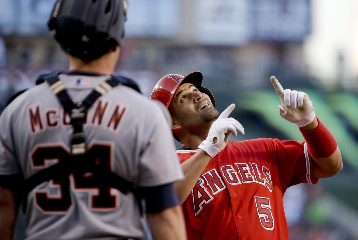 Angels first baseman Albert Pujols celebrates after hitting a two-run home run against catcher James McCann and the Tigers in the first inning Thursday night in Anaheim.