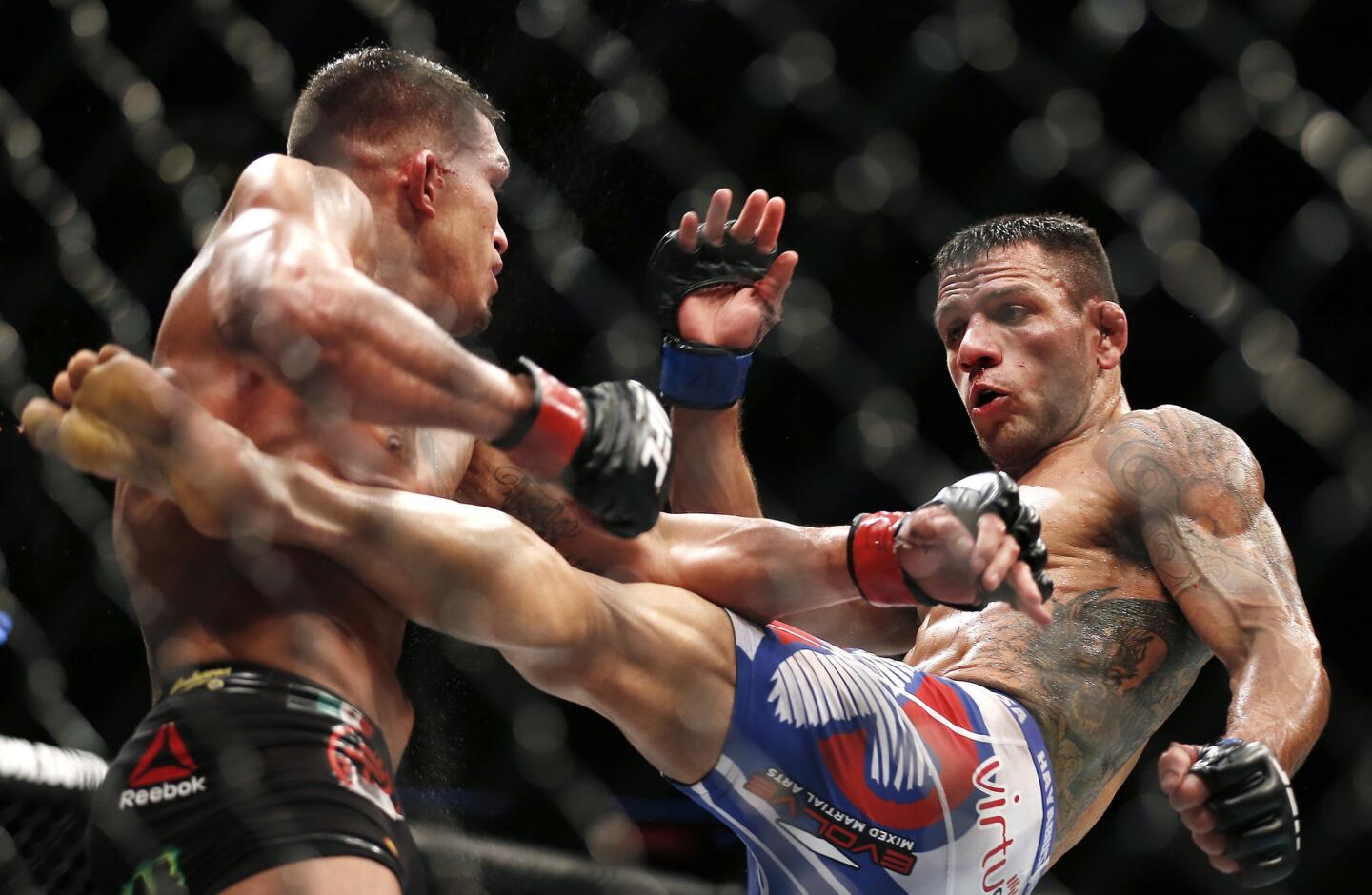 Rafael Dos Anjos, right, delivers a kick to Anthony Pettis on his way to winning the lightweight title during UFC 185 in Dallas on March 15, 2015.