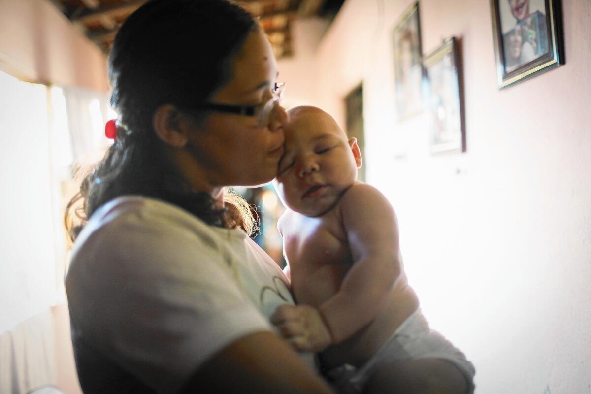 Mylene Helena Ferreira holds son David Henrique Ferreira, 5 months, in Recife, Brazil. David has microcephaly.