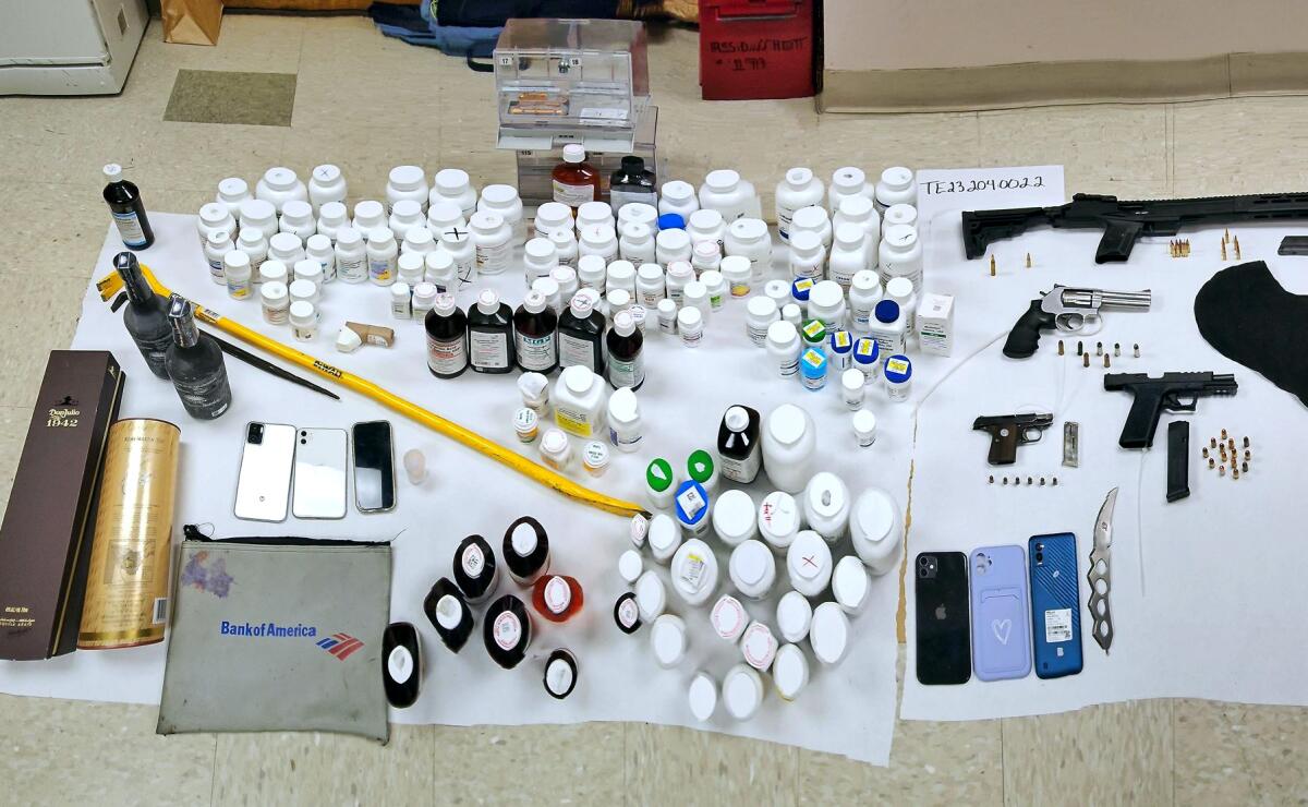 Prescription medication, alcohol, firearms and ammunition on a table