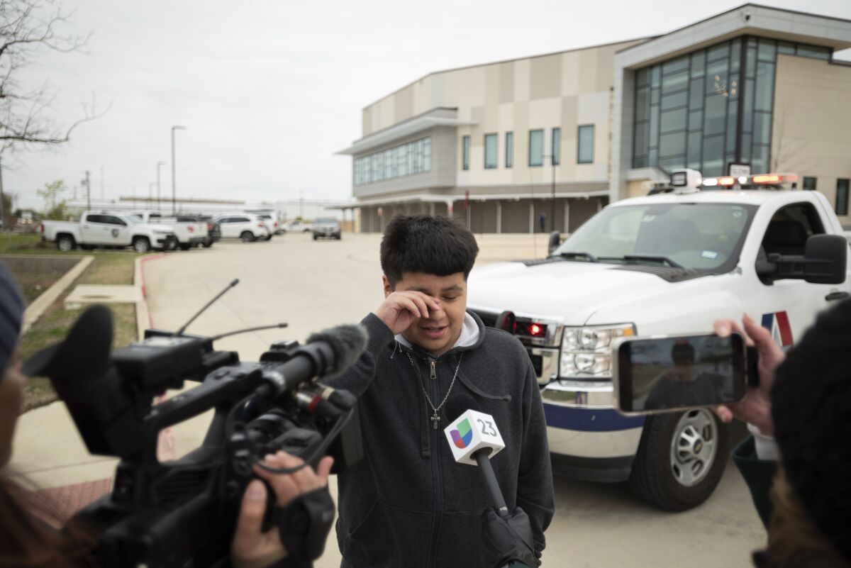 Freshman Wilber Rodriguez, 15, left, rubs his eyes while speaking to news reporters about their experience during a school shooting at Lamar High School, outside of the Arlington ISD Athletic Center after being reunited with family, on Monday morning, March 20, 2023 in Arlington, Texas. (Ben Torres/The Dallas Morning News via AP)