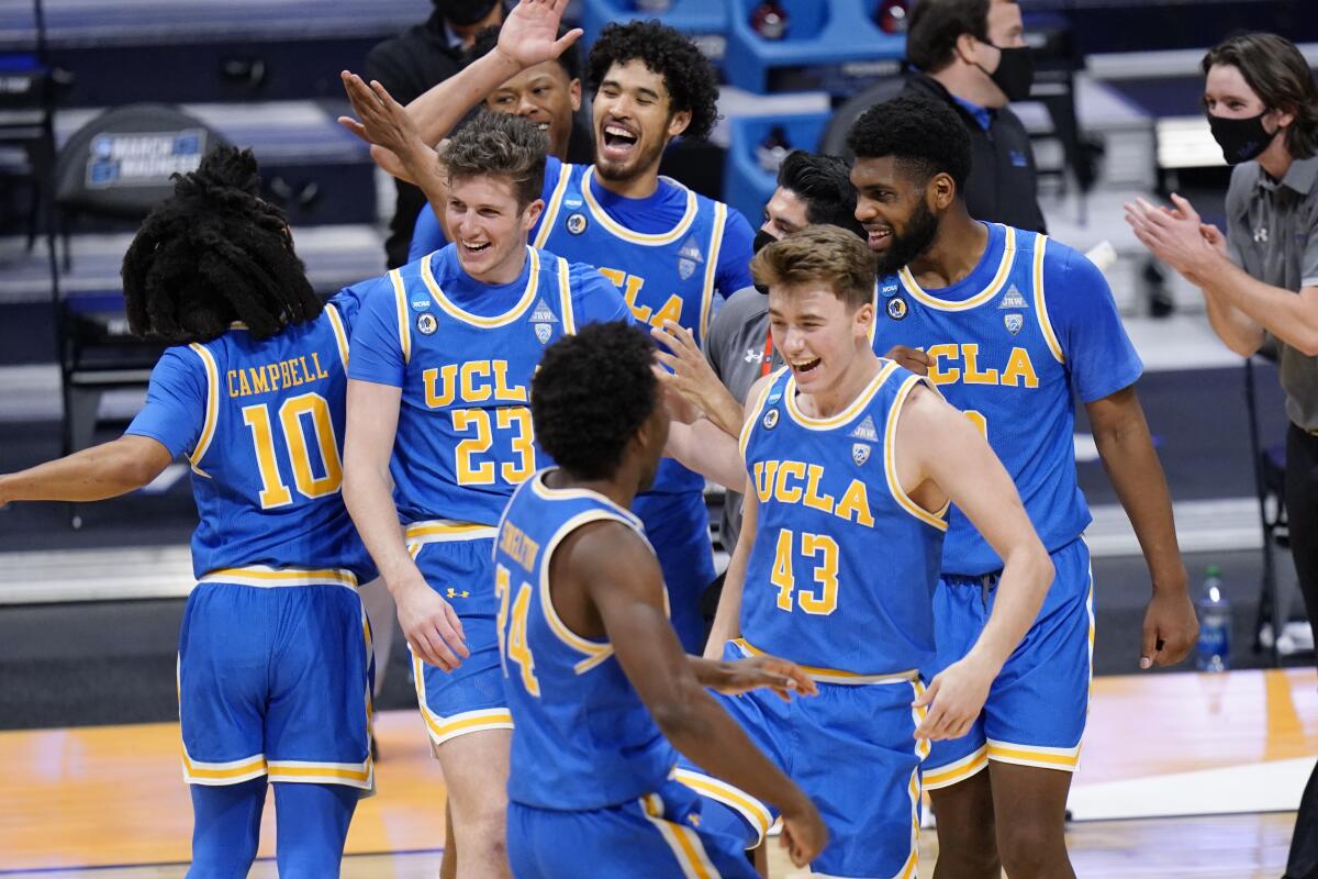 UCLA basketball players celebrate their win over BYU after a first-round game in the NCAA college basketball.