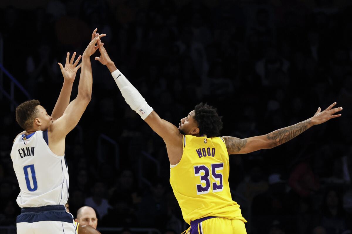 Lakers forward Christian Wood tries to block a shot by Mavericks guard Dante Exum.
