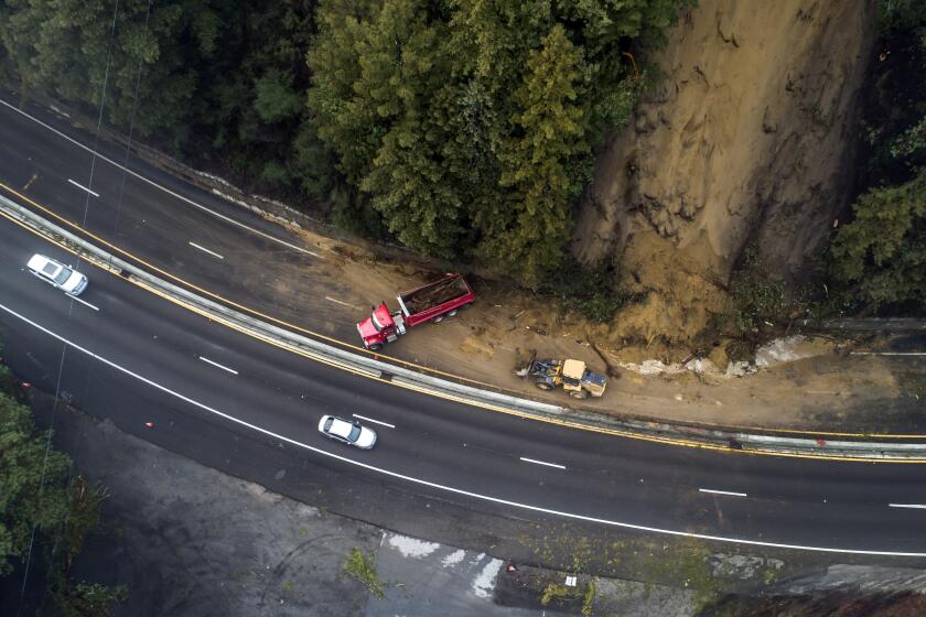 Caltrans crews work to clear a mudslide on Highway 17 that resulted from heavy rain from an atmospheric river storm in the Santa Cruz Mountains, south of Glenwood Drive in Scott's Valley, Calif., on Monday, Jan. 9, 2023. (Carlos Avila Gonzalez/San Francisco Chronicle via AP)