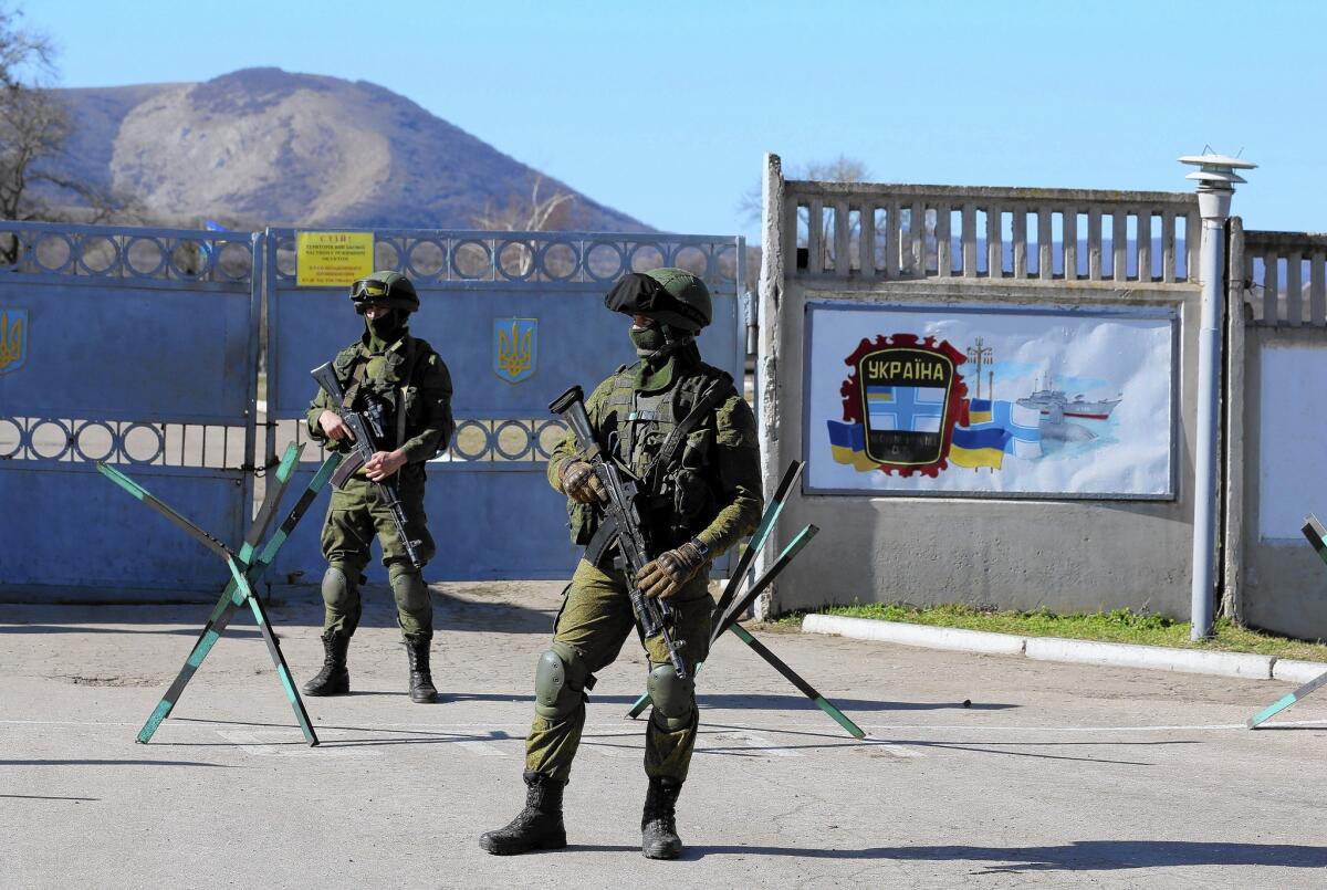 Russian soldiers stand outside a Ukrainian military base in Perevalnaya, in Ukraine's Crimea region. The facility, under siege by Russian forces for three days, faced demands that it give up its weapons.