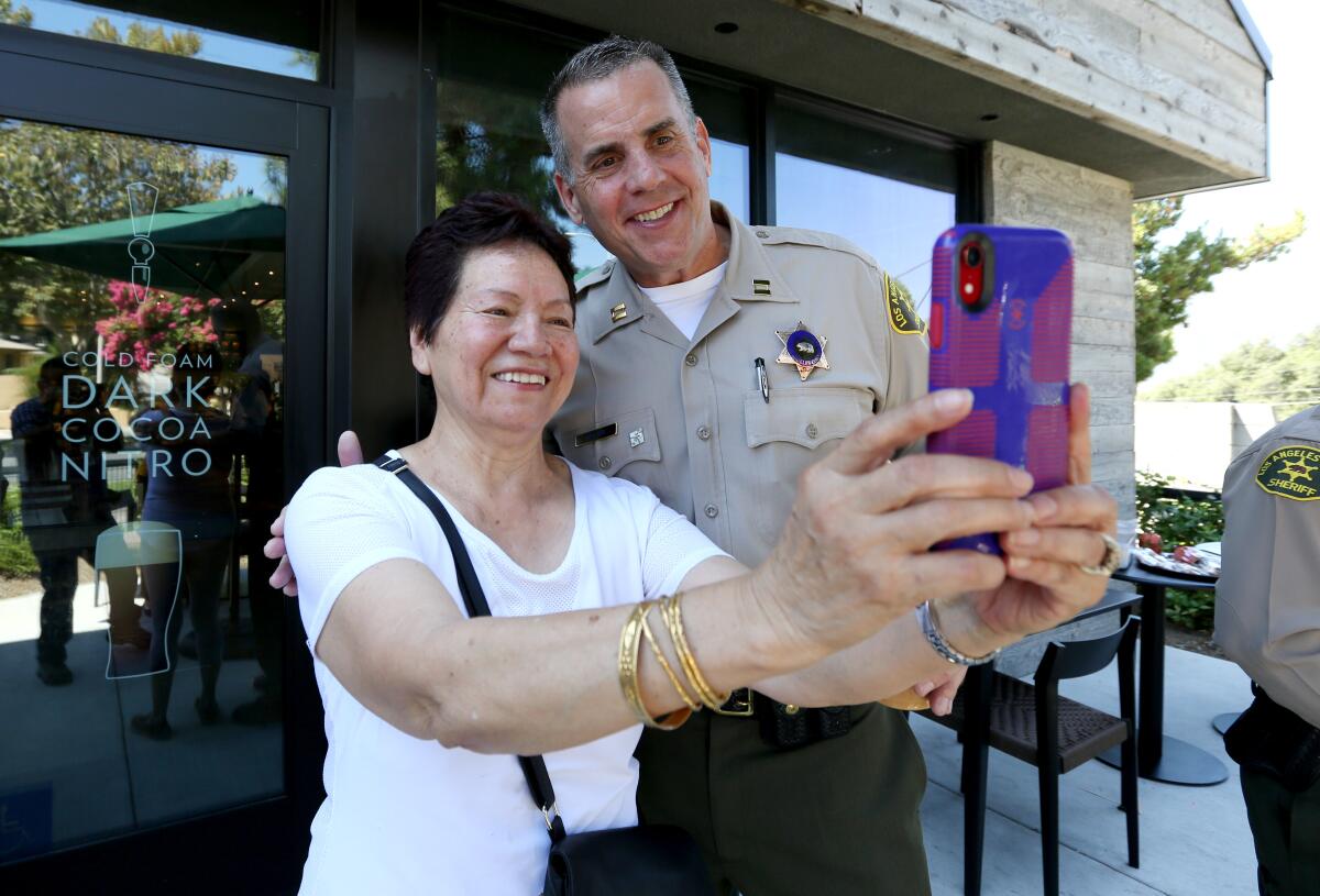 Connie Alamdari of La Cañada Flintridge takes a selfie with Crescenta Valley Sheriff Station Capt. Todd Deeds, during "Coffee with the Captain" event at the Starbucks in La Cañada Flintridge on Aug. 29.