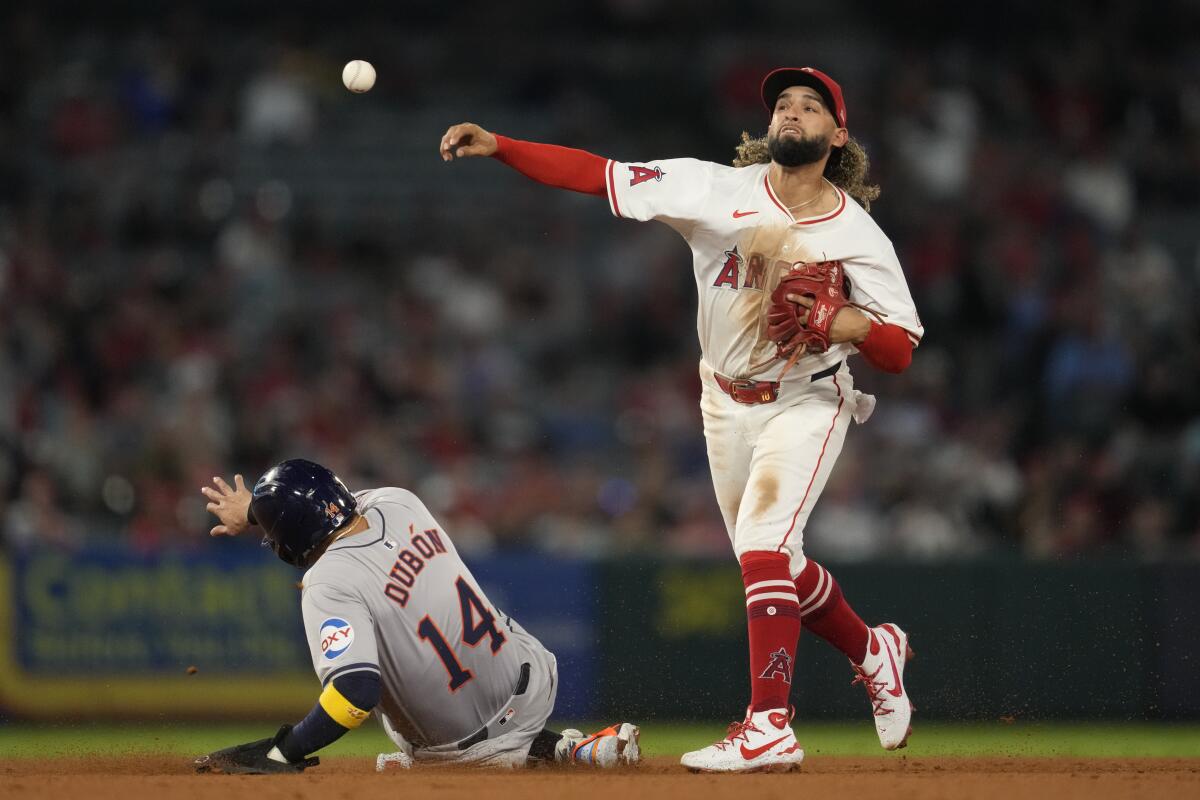 Angels shortstop Jack López throws to first to complete a double play against the Astros at Angel Stadium.