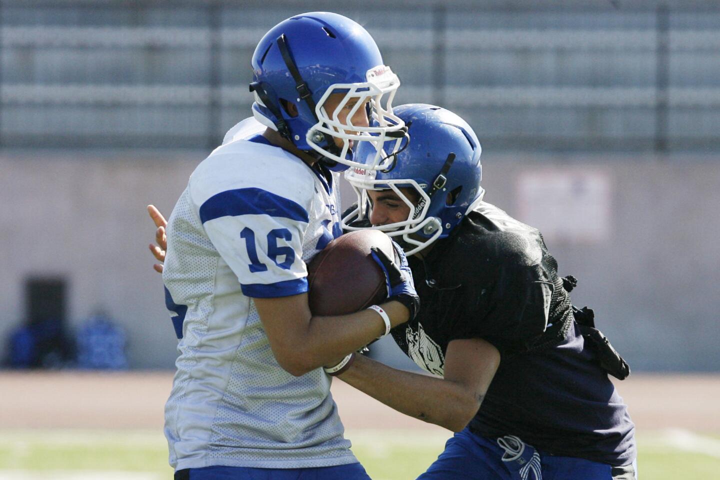 Burbank's Jacob Jimenez, left, gets tackled by Joe Argenziano during practice at Burbank High School in Burbank on Tuesday, August 14, 2012.