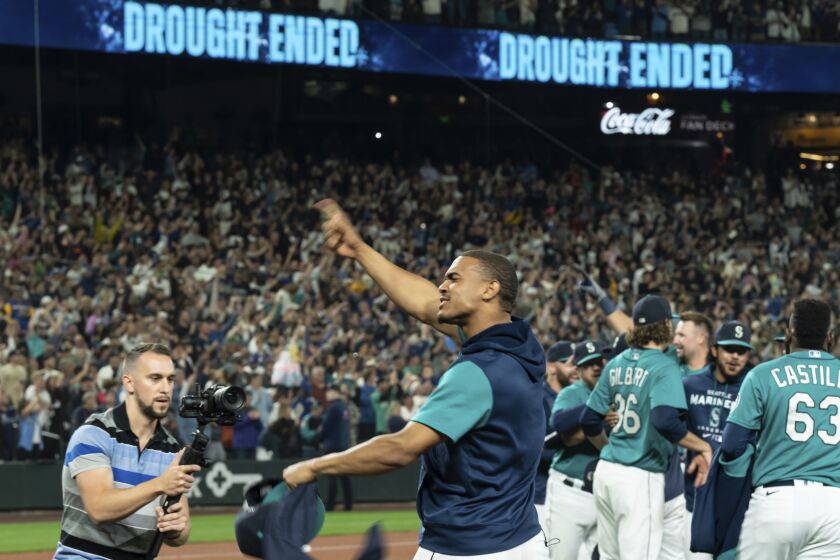 Seattle Mariners' Julio Rodriguez celebrates on the field after the team's baseball game against the Oakland Athletics, Friday, Sept. 30, 2022, in Seattle. The Mariners won 2-1 to clinch a spot in the playoffs. (AP Photo/Stephen Brashear)