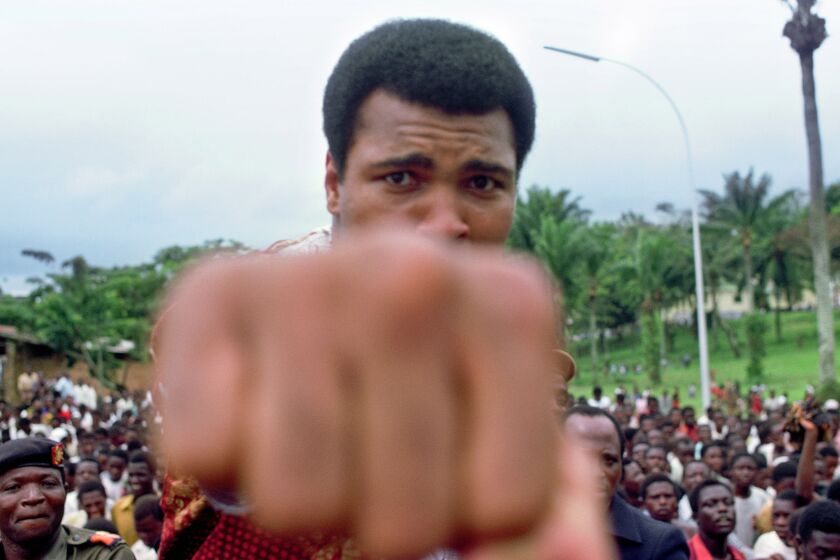 Muhammad Ali playfully throws a fist at the camera while promoting his fight against George Foreman in Zaire in October 1974.