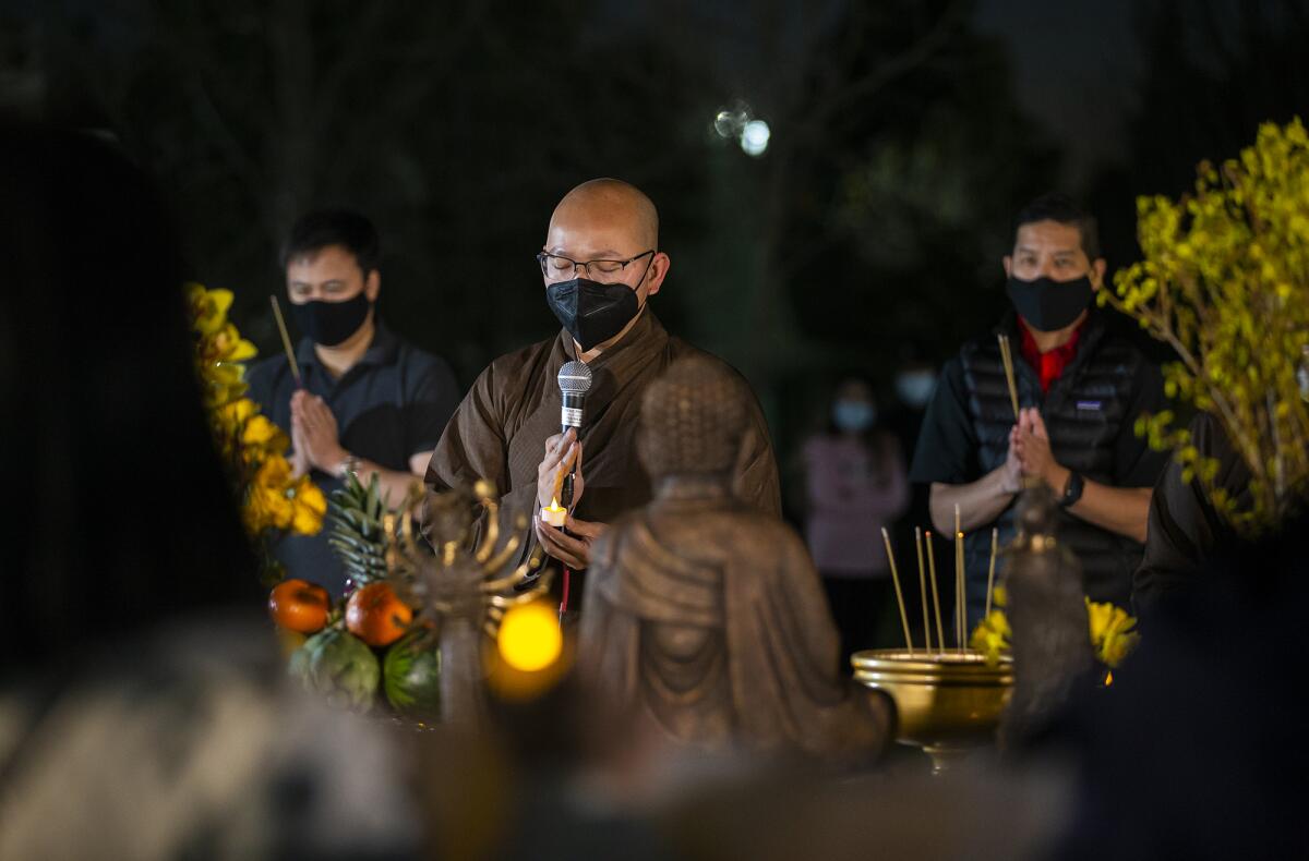 A Buddhist monk leads a prayer of peace during a "Stop Asian Hate" event at Mile Square Park on Thursday.