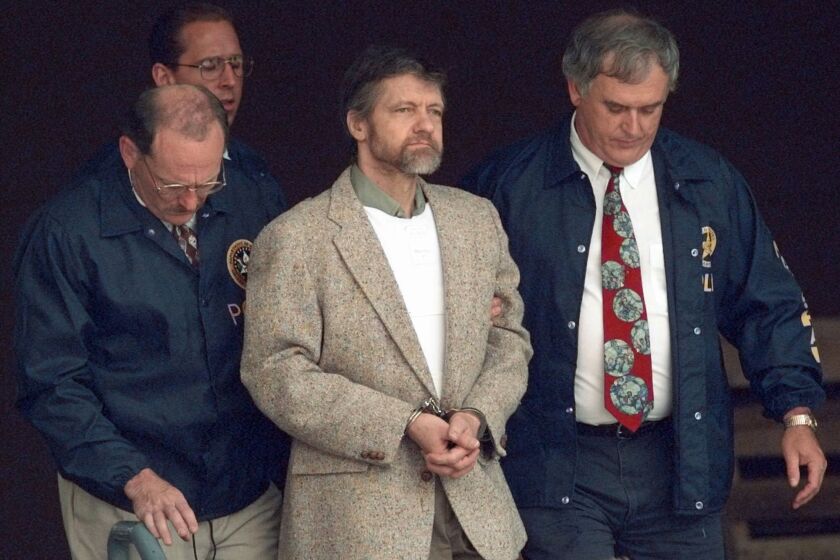 FILE - Theodore Kaczynski looks around as U.S. Marshals prepare to take him down the steps at the federal courthouse to a waiting vehicle on June 21, 1996, in Helena, Mont. A spokesperson for the Bureau of Prisons told The Associated Press that Kaczynski, known as the “Unabomber,” has died in federal prison. The cause of death was not immediately known. (AP Photo/Elaine Thompson, File)