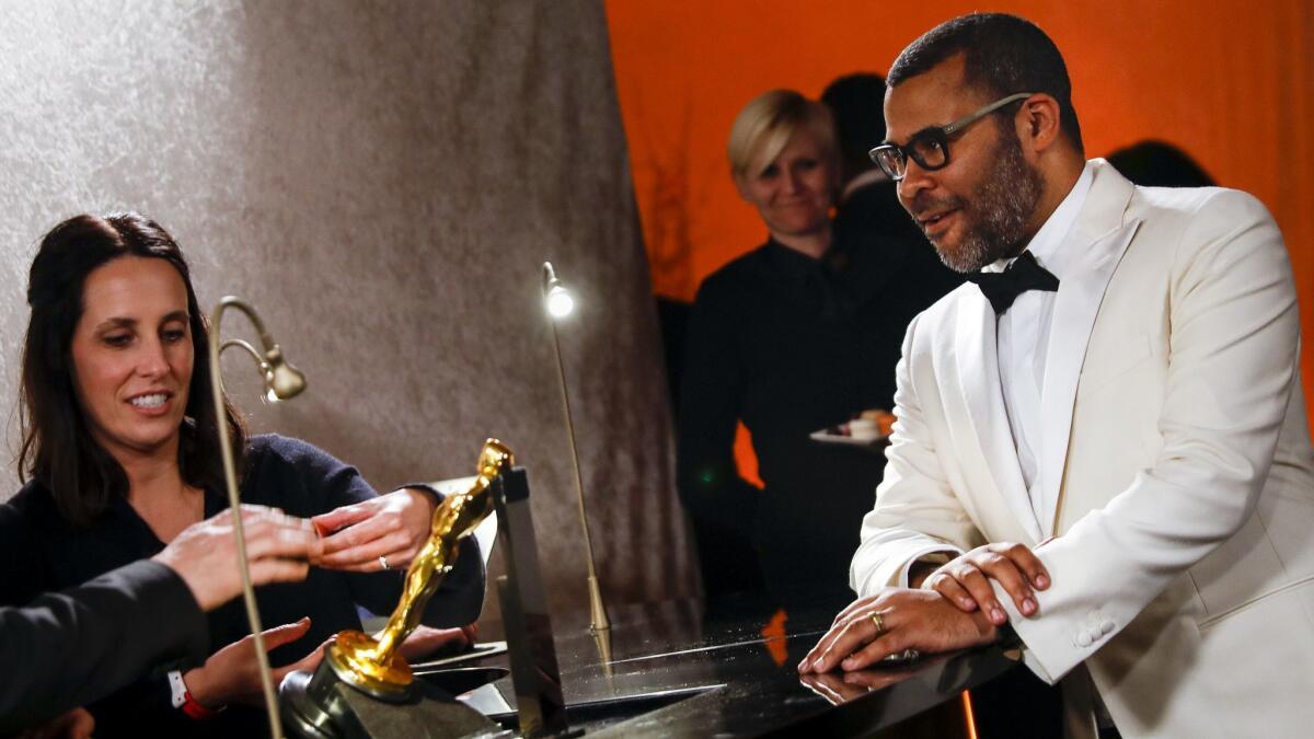 Jordan Peele examines the engraving for his original screenplay Oscar at the Governor's Ball of the 90th Academy Awards on March 04, 2018.