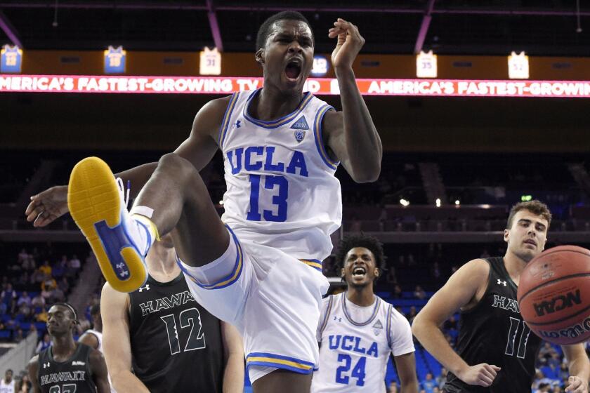 UCLA guard Kris Wilkes, center, reacts after dunking as Hawaii guard Sheriff Drammeh, left, forward Jack Purchase, second from left, and center Mate Colina, right, watch along with UCLA guard Huthifah Abdeljawad during the first half of an NCAA college basketball game, Wednesday, Nov. 28, 2018, in Los Angeles. (AP Photo/Mark J. Terrill)