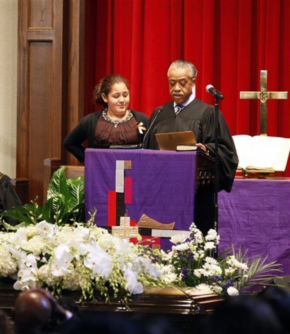 The Rev. Al Sharpton, right, reads a letter from President Barack Obama to Xea Myers 11-year-old daughter of Dwight Errington Myers, later known as Heavy D, during his funeral at Grace Baptist Church in Mount Vernon, N.Y., Friday, Nov. 18, 2011. The rapper, producer and actor died on Nov. 8, in Los Angeles. (AP Photo/David Karp)