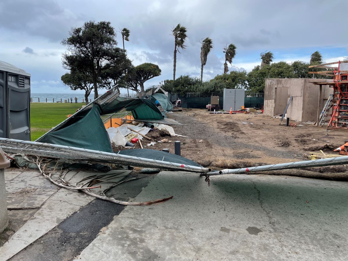 Fencing is damaged at the site of the Scripps Park restroom project as strong winds whip La Jolla on Jan. 25.