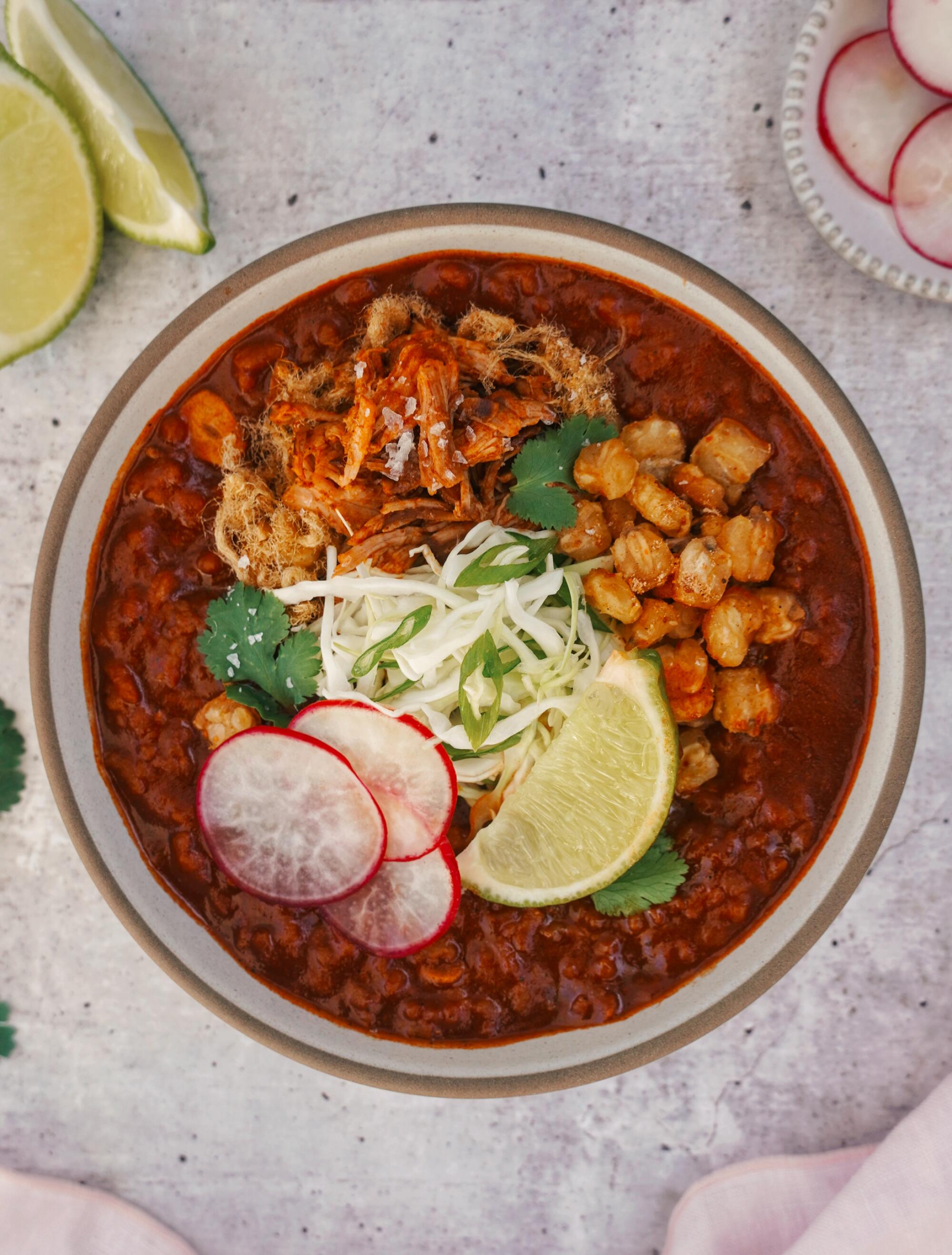 Overhead view of deep-red porridge with lime, radish and sprout garnishes