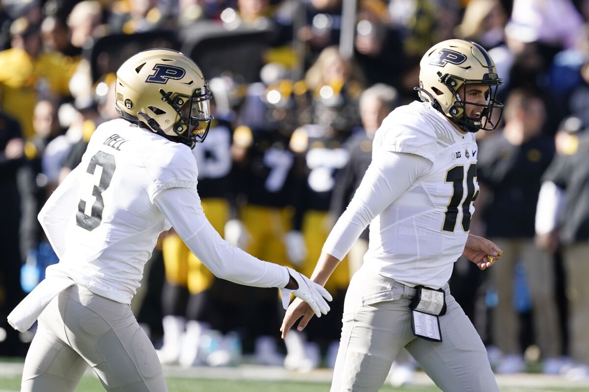 Purdue quarterback Aidan O'Connell (16) celebrates with teammate wide receiver David Bell (3) after scoring on a 6-yard touchdown run during the first half of an NCAA college football game against Iowa, Saturday, Oct. 16, 2021, in Iowa City, Iowa. (AP Photo/Charlie Neibergall)