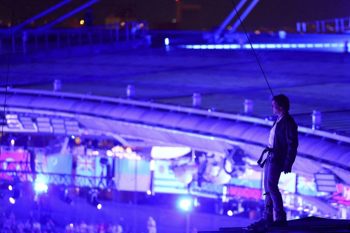 Actor Tom Cruise stands on the roof of Stade de France.