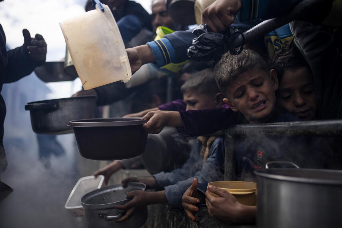 En esta imagen de archivo, palestinos hacen fila para recibir comida, en Rafah, 