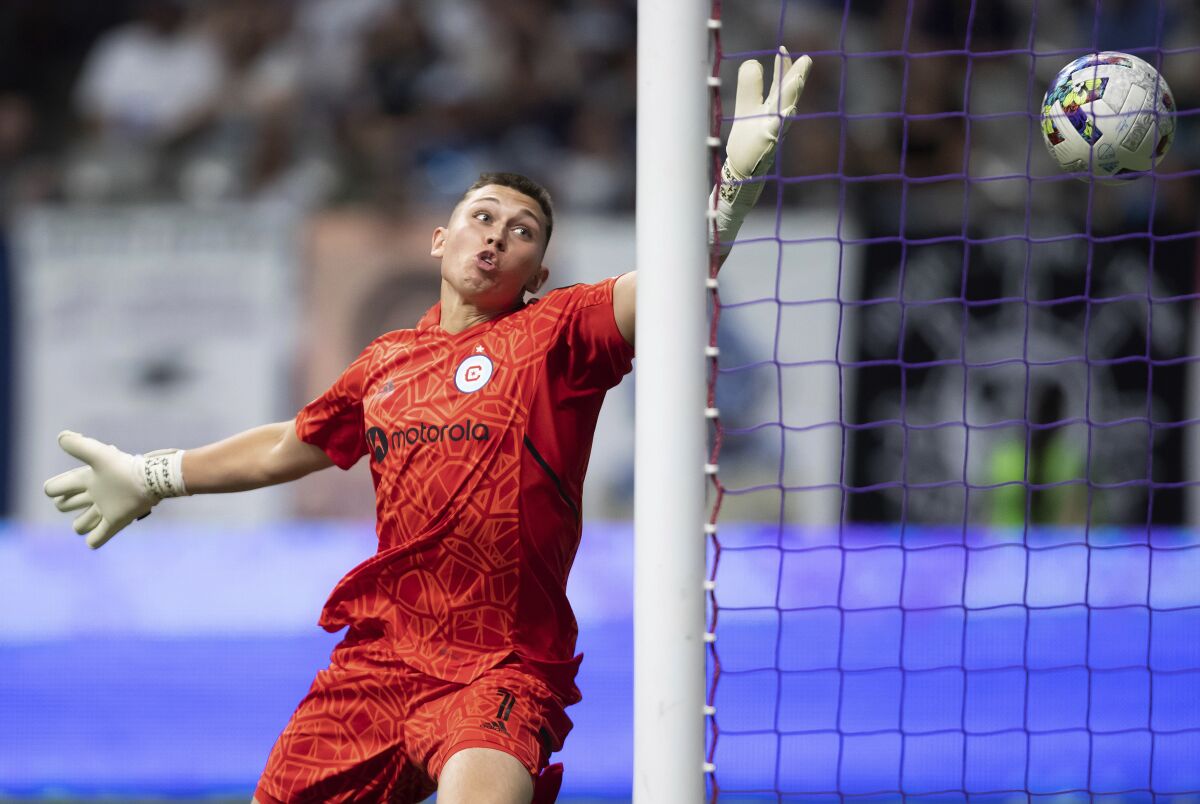 Chicago Fire goalkeeper Gabriel Slonina allows a goal to Vancouver Whitecaps' Lucas Cavallini during the second half of an MLS soccer match Saturday, July 23, 2022, in Vancouver, British Columbia. (Darryl Dyck/The Canadian Press via AP)