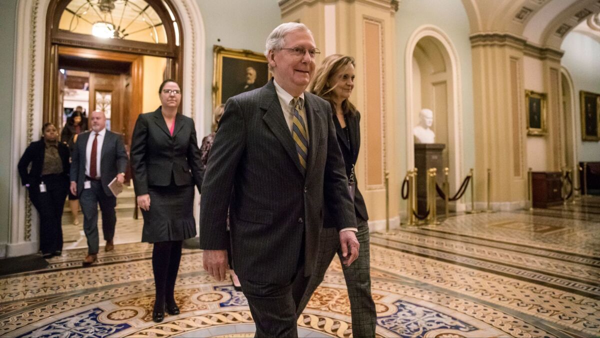 After speaking on the floor, Senate Majority Leader Mitch McConnell, R-Ky., leaves the chamber as a bitterly-divided Congress hurtles toward a government shutdown at the Capitol in Washington, Friday, Jan. 19, 2018.