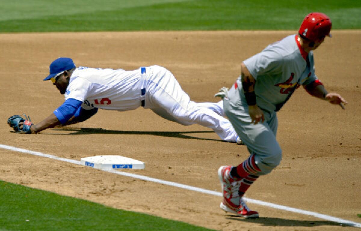 Dodgers third baseman Juan Uribe dives but can't stop a ball hit by the Cardinals' Pete Kouzma (not pictured) for a three-run double that scored, among others, Yadier Molina.