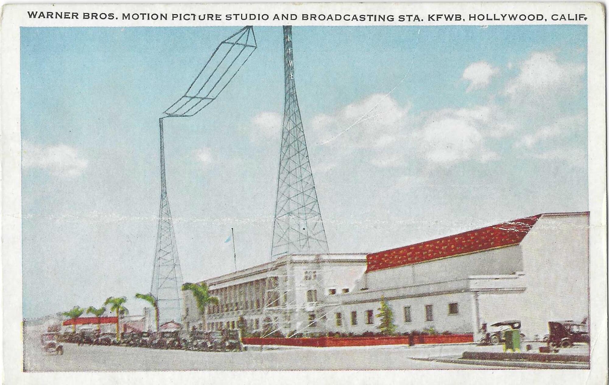 Broadcast towers above a white and red building on an old postcard.