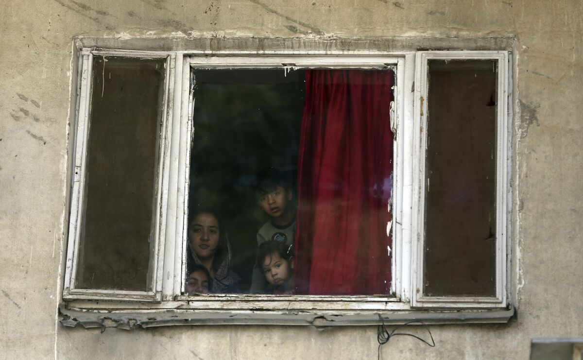 Children peer from their home in Kabul, Afghanistan, on Tuesday amid a lockdown.