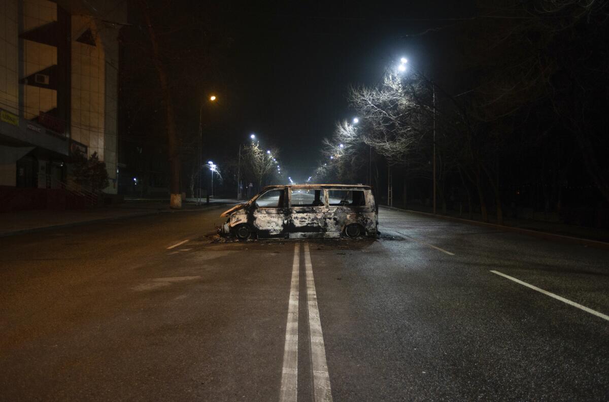 A burned police vehicle in the middle of an empty street
