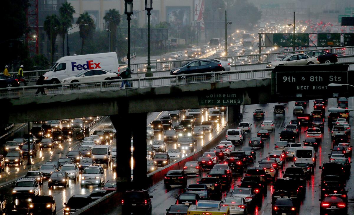 Traffic slows on the Harbor Freeway as the rain falls in downtown Los Angeles.