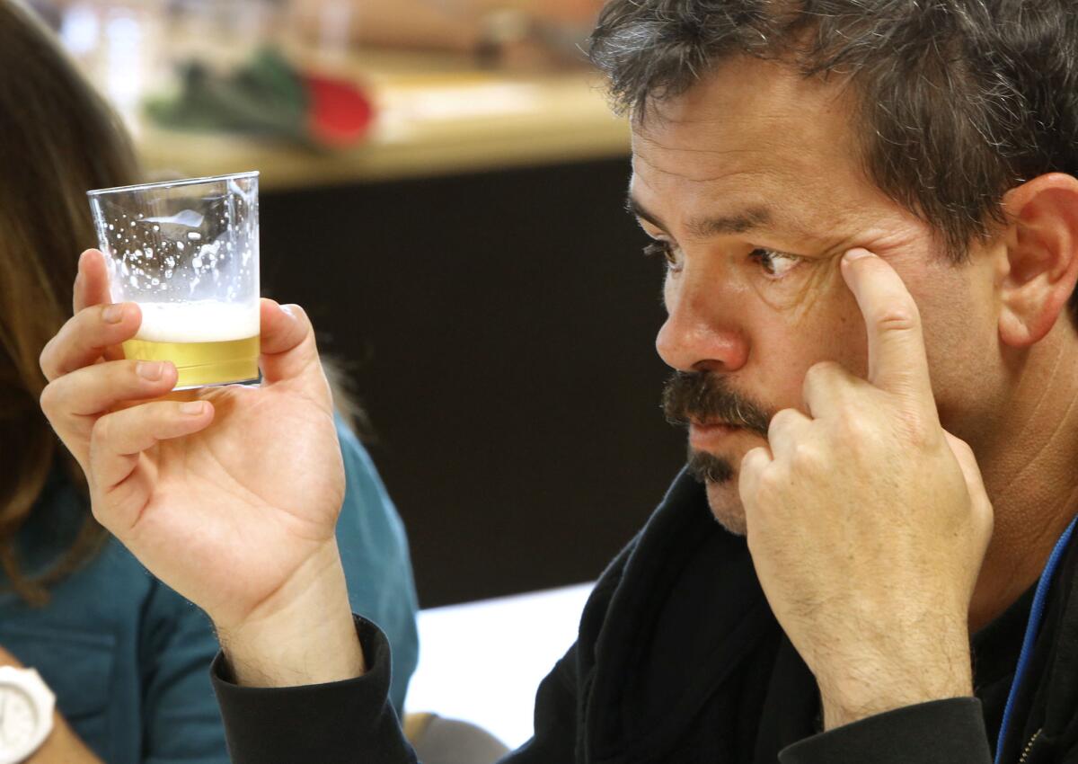 Steve Gonzalez, a judge for the California State Fair Commercial Craft Brew Competition, checks the color and clarity of a Kolsch beer during the judging in West Sacramento.