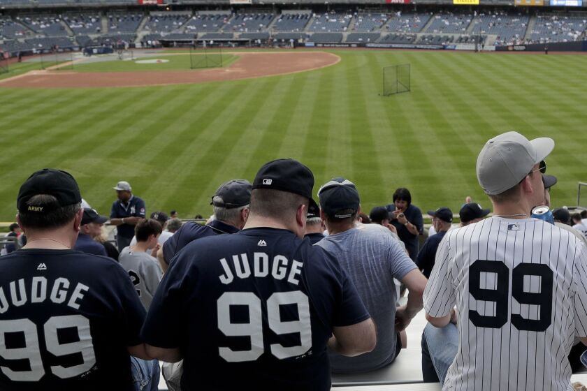 FILE - In this May 4, 2018, file photo, baseball fans wearing New York Yankees' Aaron Judge (99) jerseys watch batting practice before a baseball game between the New York Yankees and the Cleveland Indians, in New York. Aaron Judge once again has baseballs most popular jersey. MLB says the Yankee sluggers No. 99 was the top seller for the second straight season.(AP Photo/Julie Jacobson)