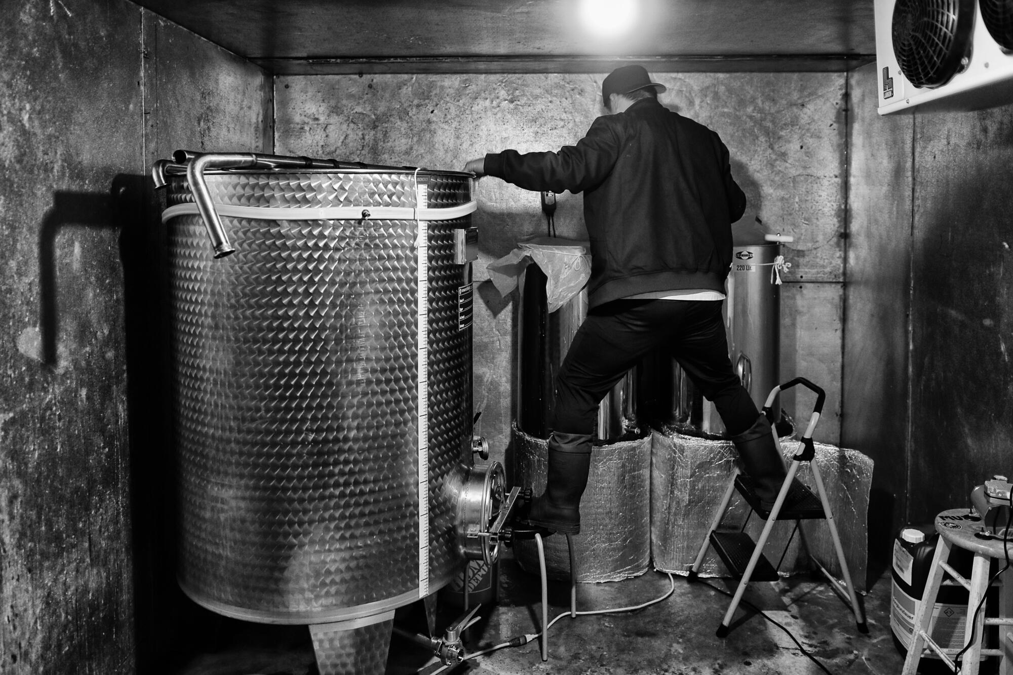 James Jin balances on steps as he prepares a vat for his Gravity brand of sake