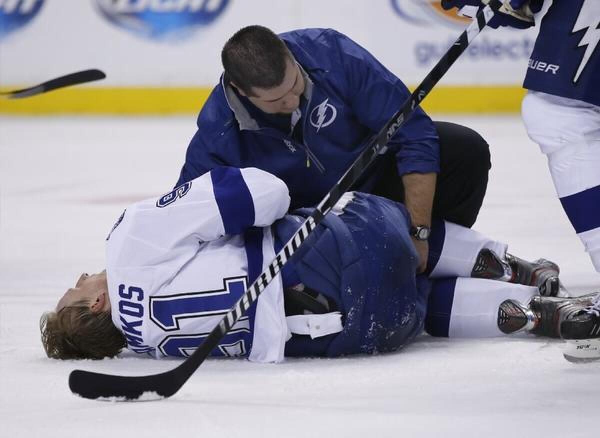 Tampa Bay Lightning center Steven Stamkos is attended to on the ice after banging into the goalpost during the second period of a game against the Boston Bruins on Monday.