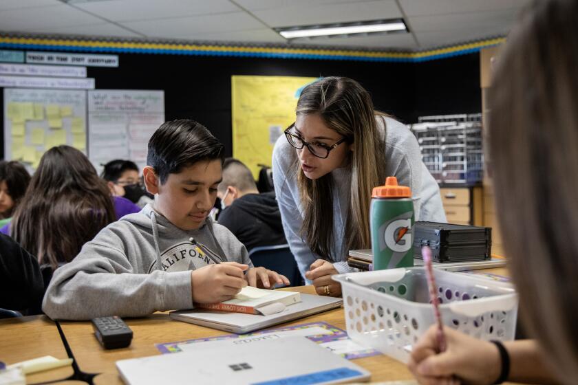 Chula Vista, California - March 04: Sixth grader Lucas Seda, 12, works with Carolina Abrego after reading a portion of "The Giver" at Rohr Elementary School on Monday, March 4, 2024 in Chula Vista, California. Abrego is part of a teacher residency program and has been with the students since the beginning of the school year. The program takes 18 months to complete. (Ana Ramirez / The San Diego Union-Tribune)