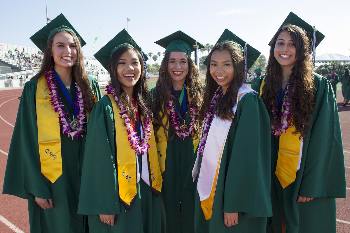 From left, valedictorians Natalie Tetreault, Sophie Nguyen, Melissa Folkerts, Laura Le and Lauren Smith at Costa Mesa High School's Class of 2015 graduation ceremony at Jim Scott Stadium on Thursday.