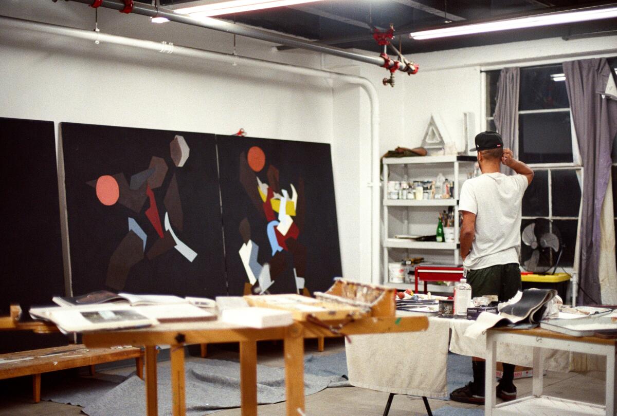 man looks at a painting in studio 