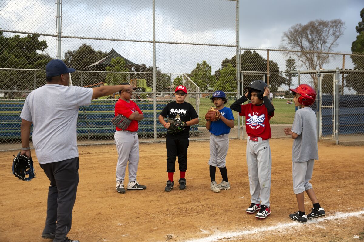 Children from the San Diego American Little League practice baseball at Memorial Park in Logan Heights on Oct. 11.