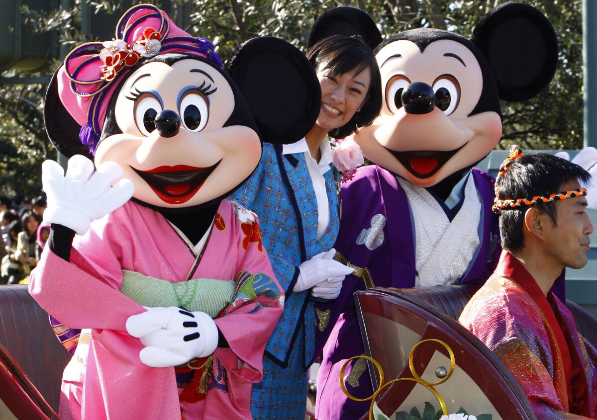 Mickey Mouse and Minnie Mouse characters wave to visitors during the annual Disney characters' procession at the Tokyo Disneyland in Urayasu, near Tokyo. The owner of the park plans a major expansion and renovation.