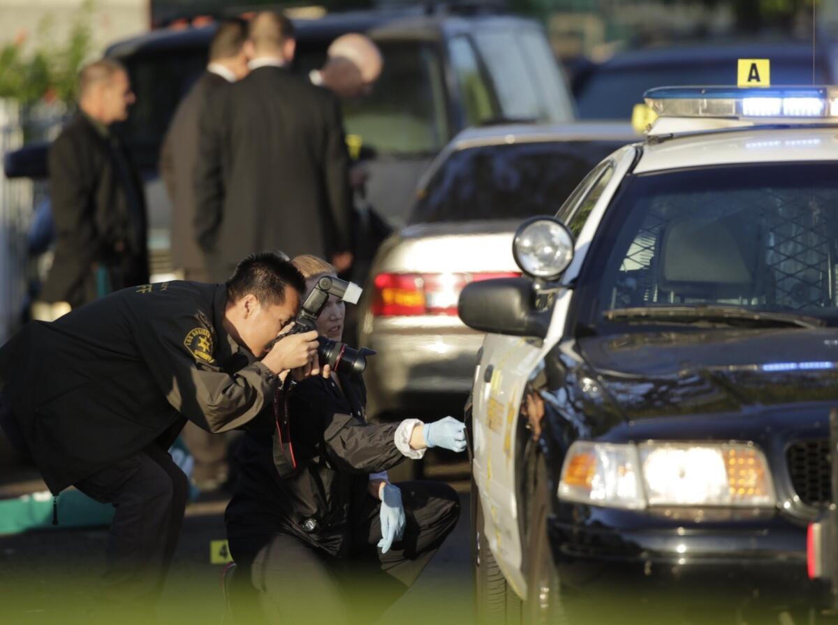 Crime scene investigators collect evidence after a motorist who allegedly tried to run over a Los Angeles County sheriff's deputy was shot by the deputy and died.
