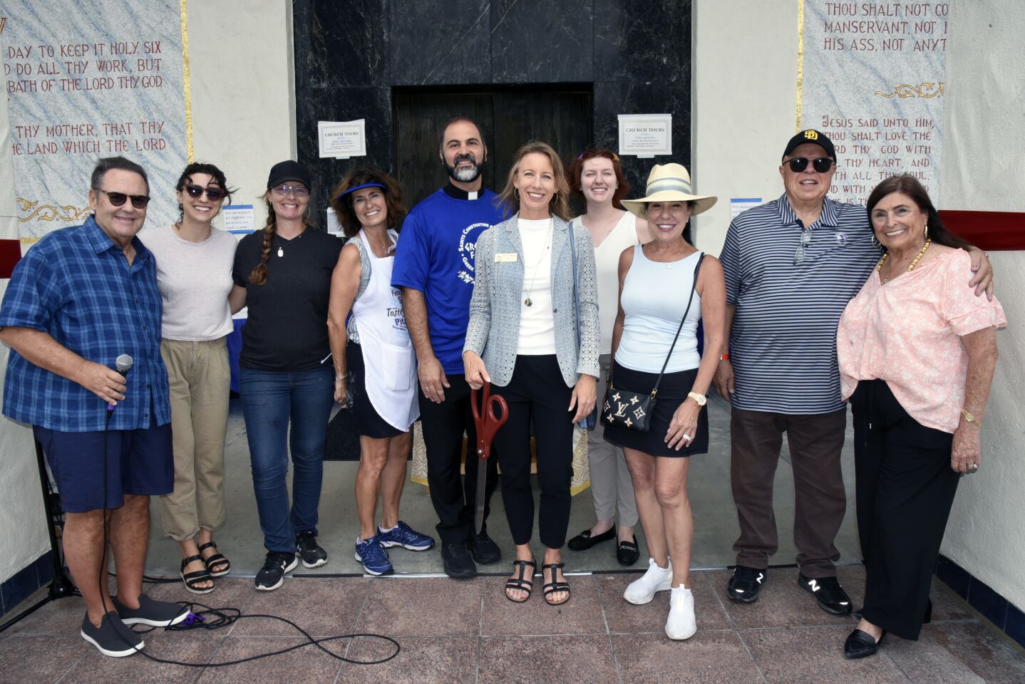 Encinitas Mayor Catherine Blakespear and Saints Constantine and Helen Greek Orthodox Church Reverend Father Angelo Maginas are joined by supporters at the ribbon cutting to celebrate the return of the Cardiff Greek Festival