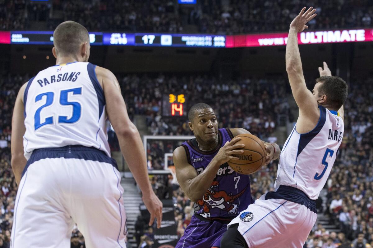 Toronto's Kyle Lowry drives between Dallas' Chandler Parsons, left, and Jose Juan Barea on Friday.