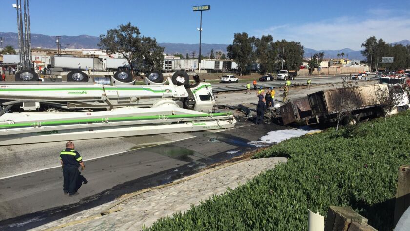 A concrete truck lies toppled after crashing through the guardrail and into oncoming traffic on the I-10 at Riverside Ave. in Rialto.