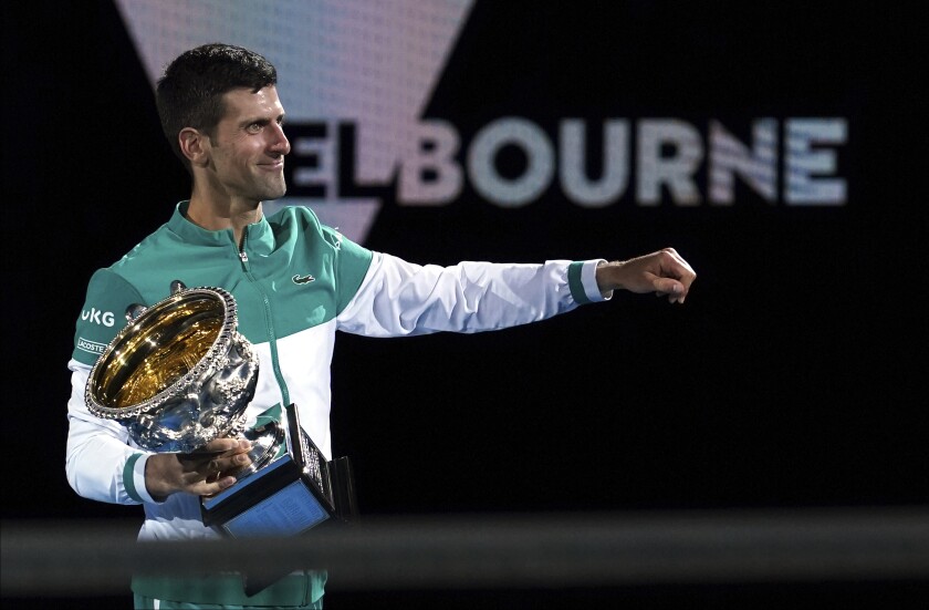FILE - Serbia's Novak Djokovic holds the Norman Brookes Challenge Cup after defeating Russia's Daniil Medvedev in the men's singles final at the Australian Open tennis championship in Melbourne, Australia, Sunday, Feb. 21, 2021. Djokovic has had his visa canceled and been denied entry to Australia, Thursday, Jan. 6, 2022, and is set to be removed from the country after spending the night at the Melbourne airport as officials refused to let him enter the country for the Australian Open after an apparent visa mix-up. (AP Photo/Mark Dadswell, File)